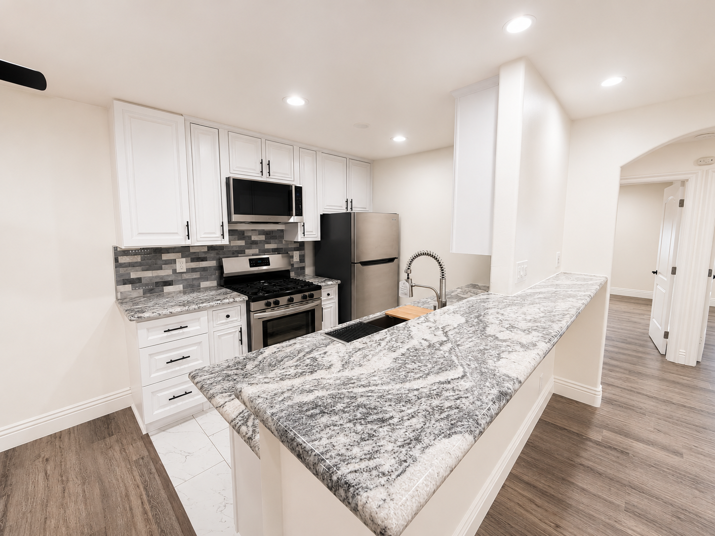 Actual vacant Residence 11 white kitchen and granite breakfast counter